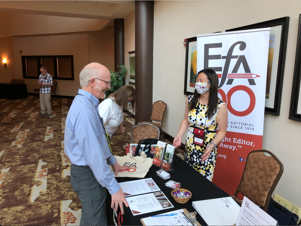 John Olsen, past President the League of Utah Writers, visiting the EFA table staffed by booth captain Crystal Shelley and Chris Thomas in the background.