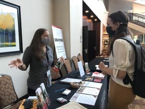 Volunteer Kristy Gilbert speaking with a booth visitor